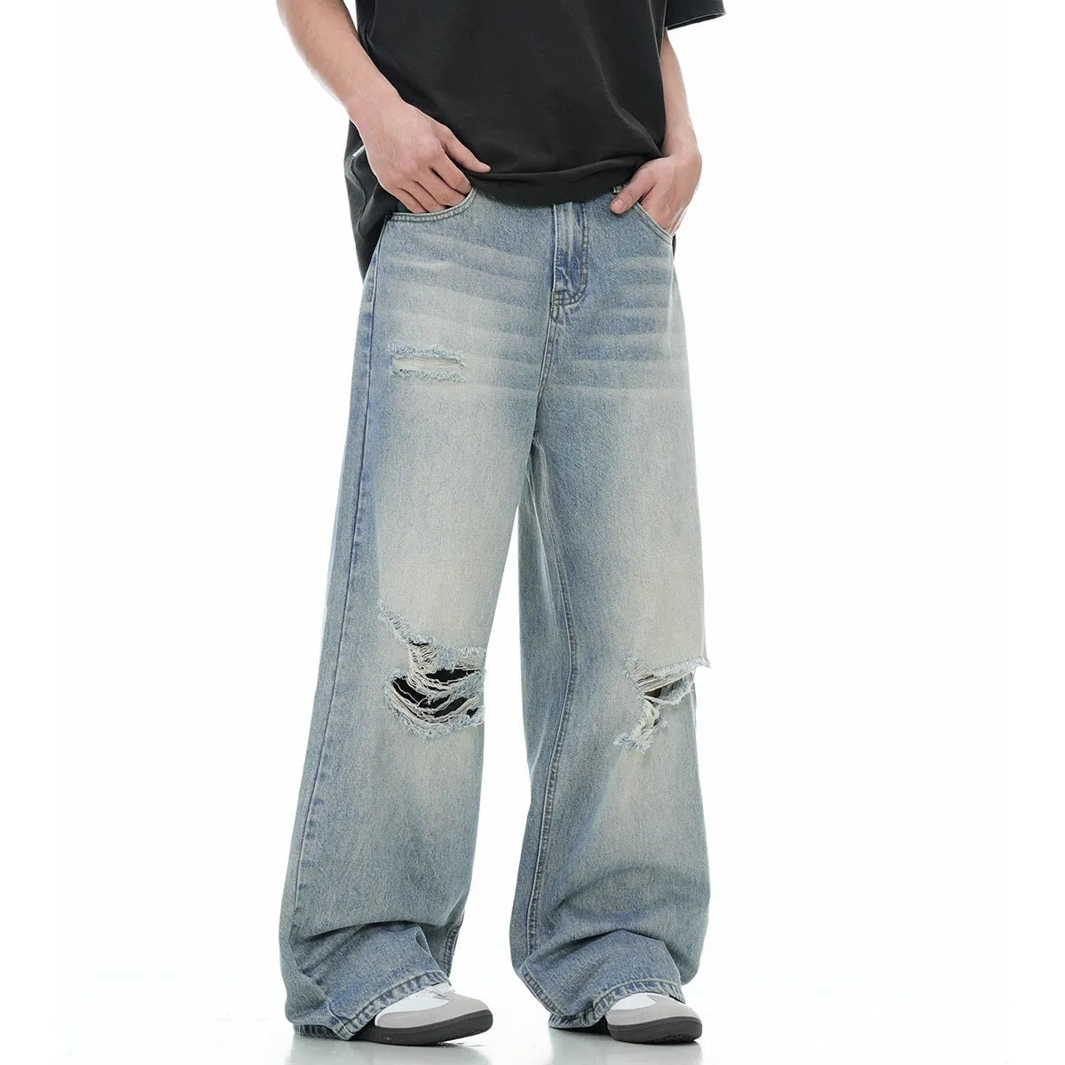 Man wearing blue ripped straight-leg jeans in a retro style with a zip fly.