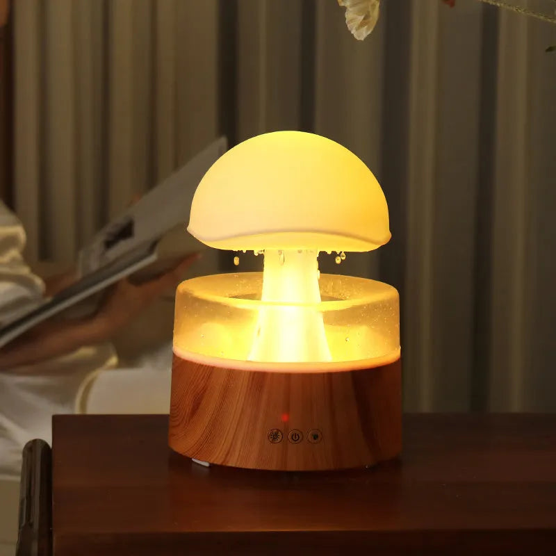White cloud-shaped ultrasonic aroma diffuser and humidifier with simulated raindrops and coloured lights.