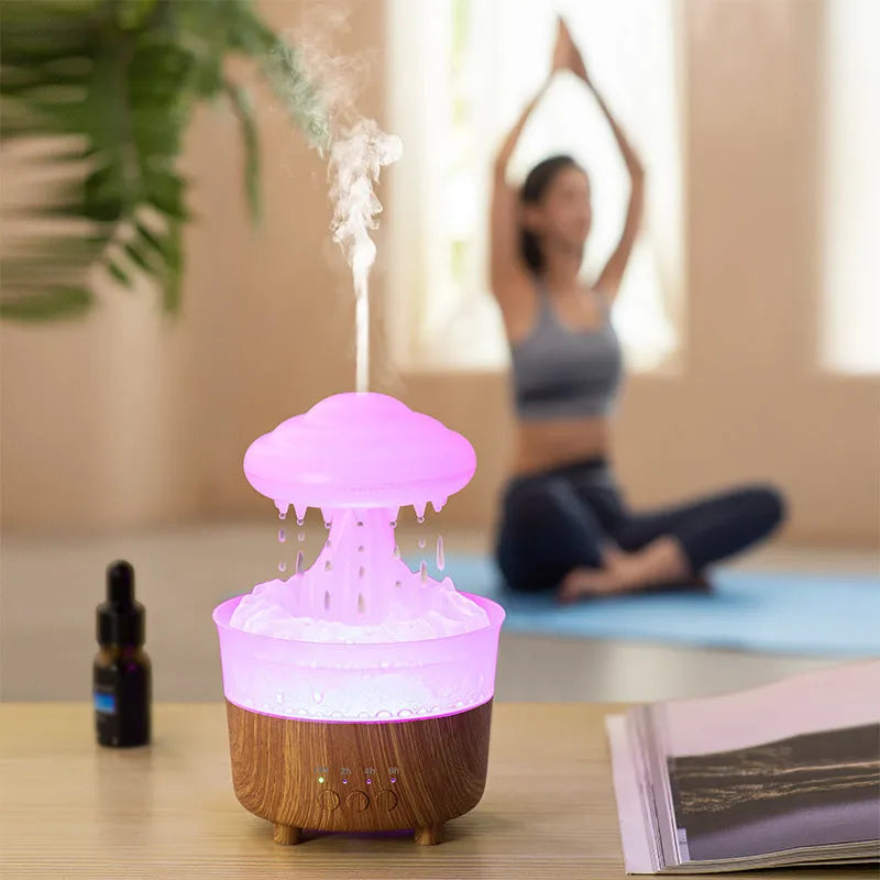 Wood grain rain cloud shaped humidifier and essential oil diffuser with night light on a table.
