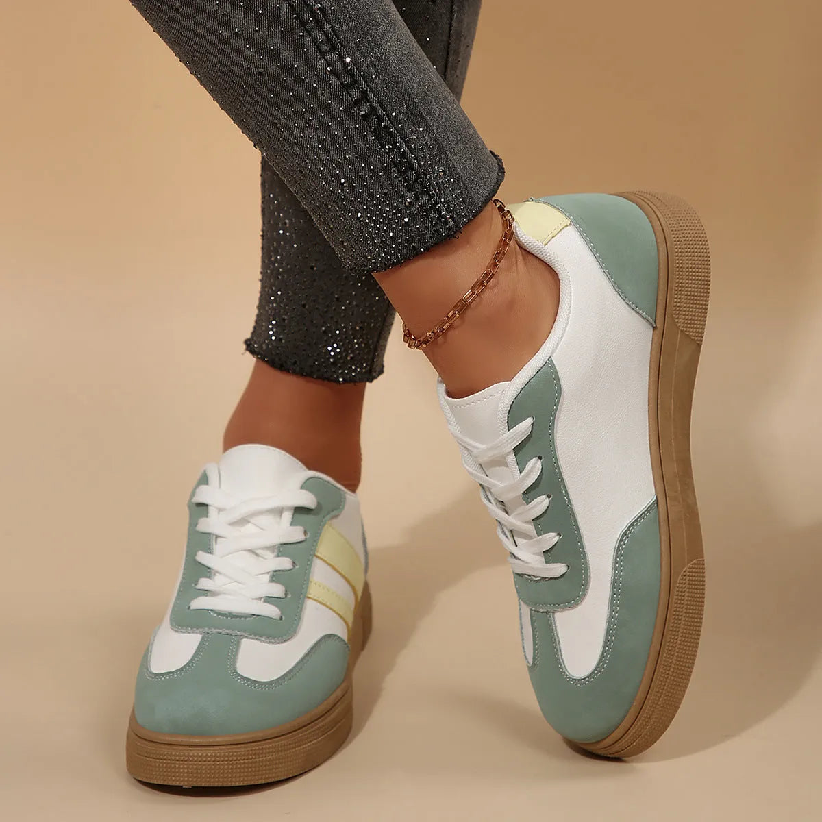 Green women's retro sports pumps with cross straps, leather stitching, and a round toe on a rubber sole.