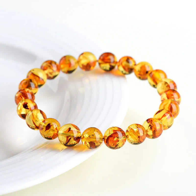 A geometric-bead amber bracelet with natural yellow piebald colouration on a wrist.