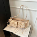 Women's pleated shoulder bag with a tassel bow, shown in multiple colours including apricot and black.