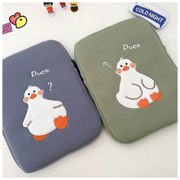 Blue cotton tablet case with embroidered cartoon duck design and a black zipper, shown open.
