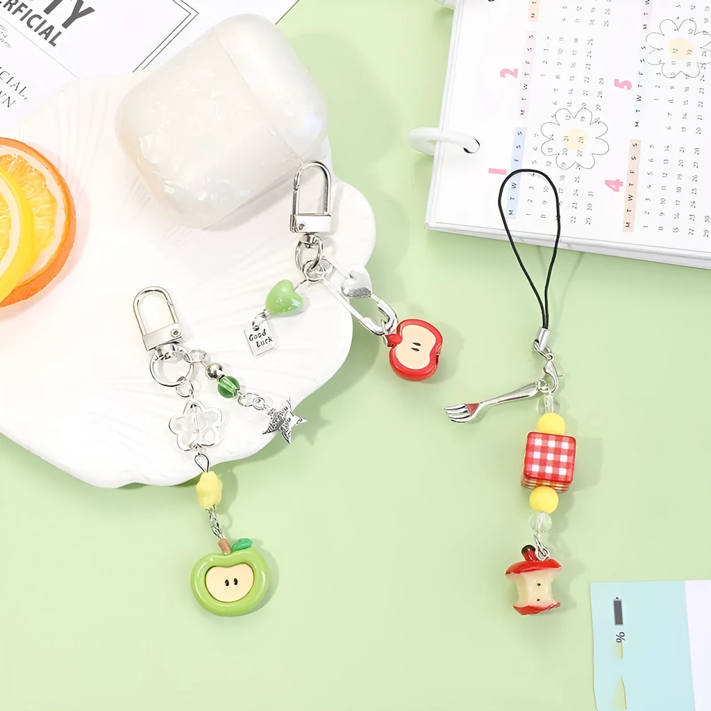 Fruit-themed mobile phone charm keychain with apple and strawberry designs in plastic/resin construction