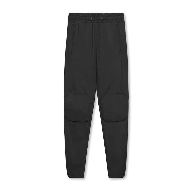 Men's loose-fit grey fitness trousers with elasticated ankle cuffs on a plain background.