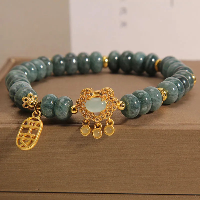 Close-up of a women's bracelet with green emerald jade and silver alloy abacus beads and a safety lock clasp.