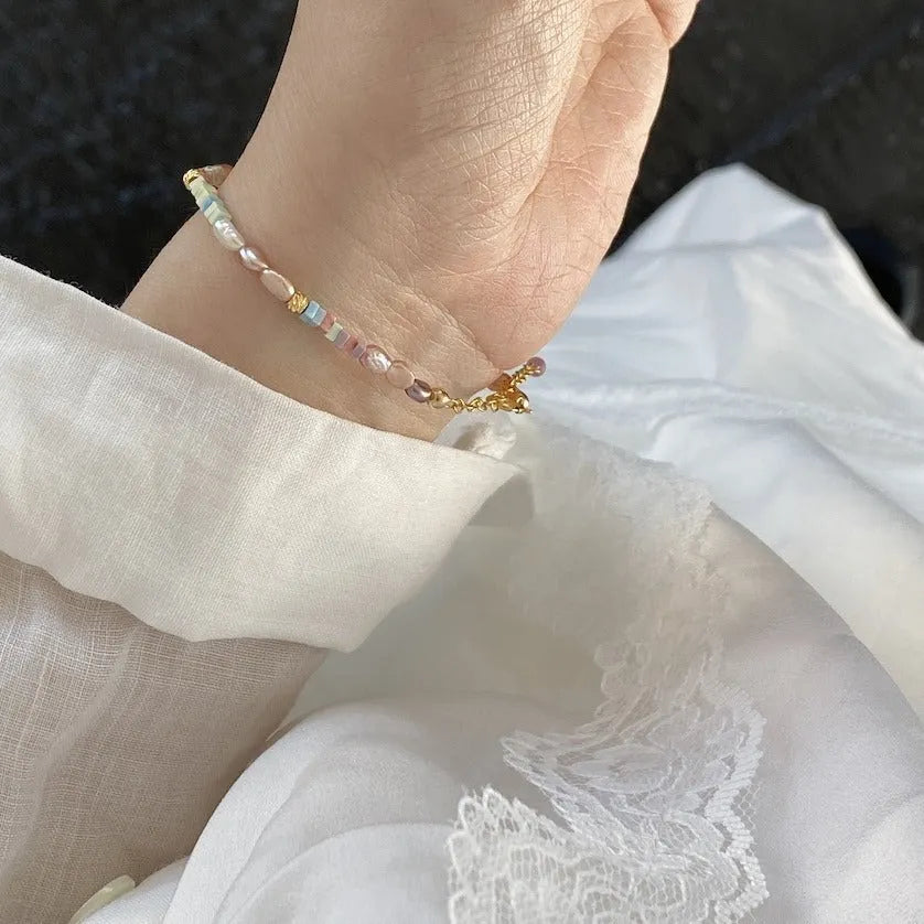 A women's bracelet and necklace set with irregular natural pearls and a 14K gilded purple finish.