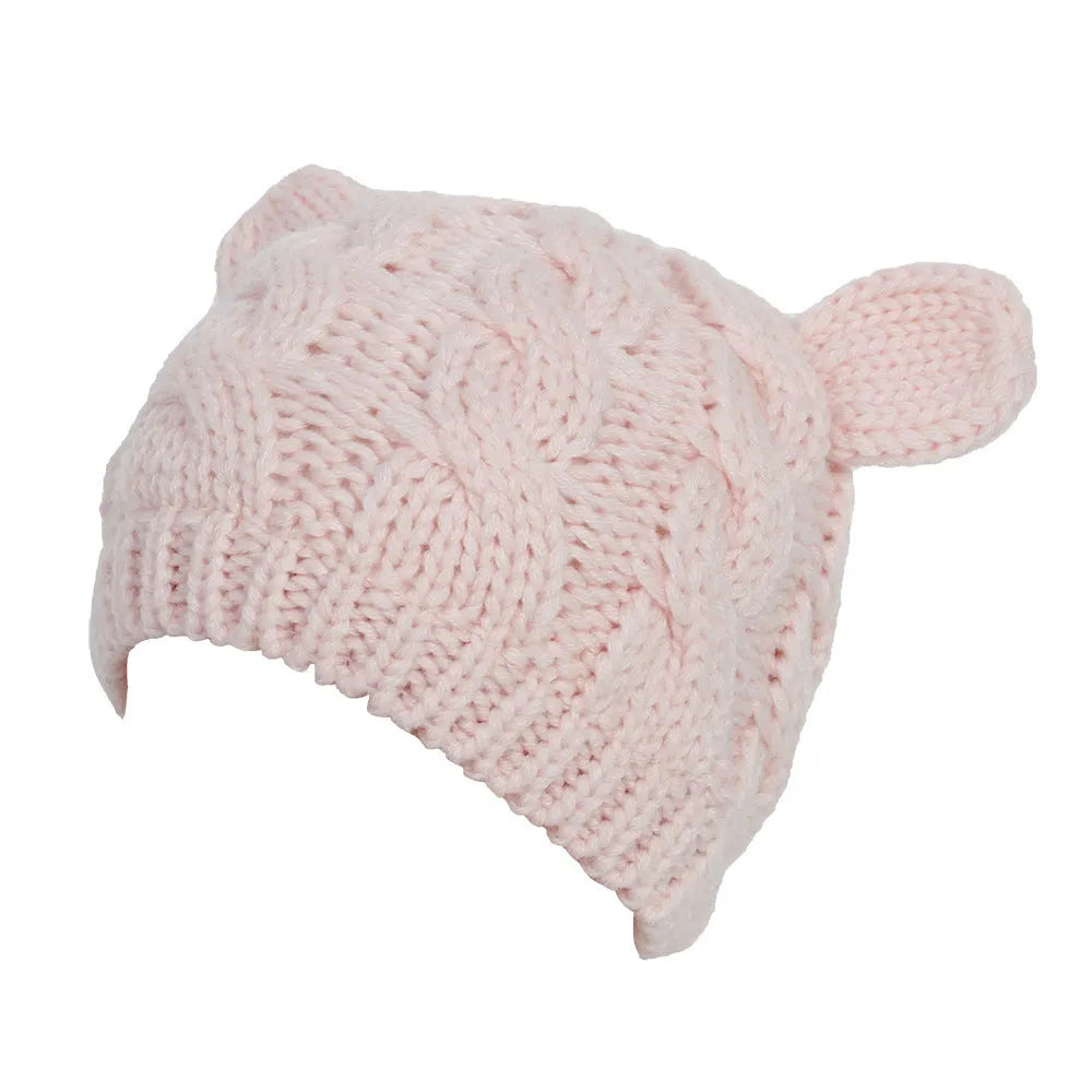 Hand knitted red wool beanie with 3D cat ears on a white background