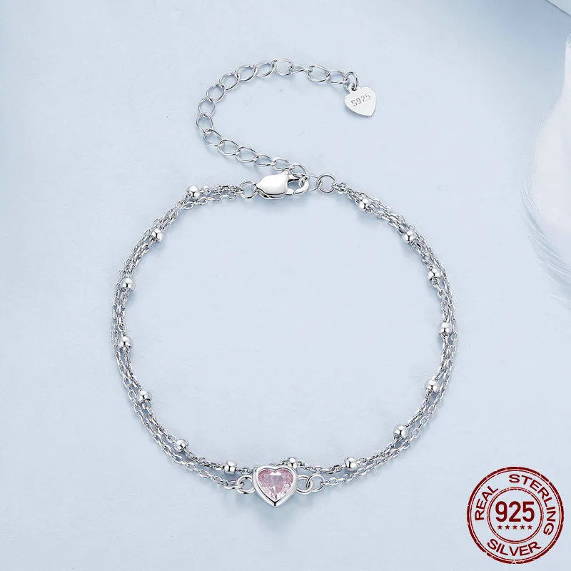 Women's sterling silver bracelet with a small heart-shaped pendant on an adjustable chain.
