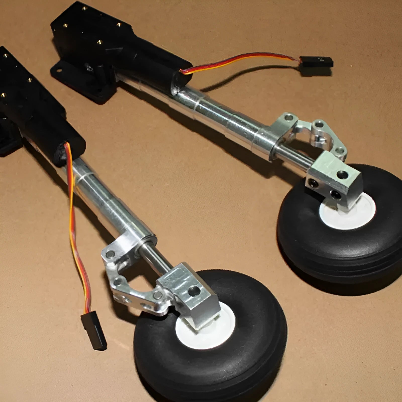Alloy retractable shock-absorbing landing gear for model aircraft with optional wheels.