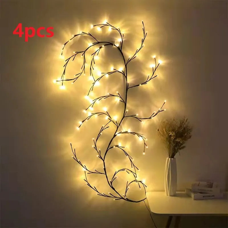 Flexible plastic LED willow vine garland with warm white lights bent into a decorative shape on a wall.