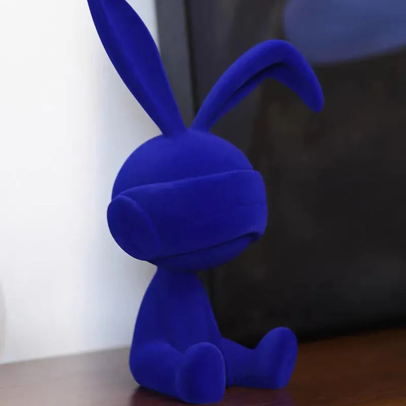 Green suede-finish resin ornament of a blindfolded rabbit for table decoration.