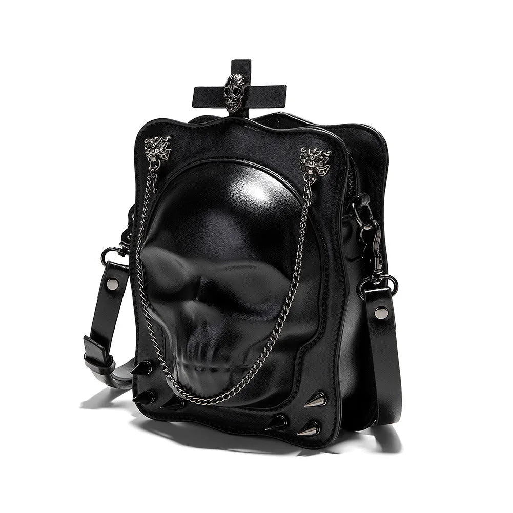Black mini square crossbody bag with embossed skull design, metal chain strap, and zip opening.