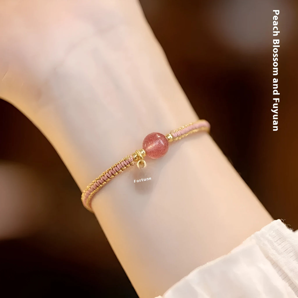 Adjustable red rope bracelet with a choice of Strawberry Quartz or Hetian Jade bead, showing the national style design.