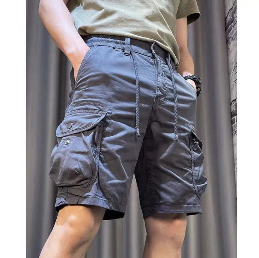 Loose straight-leg casual overalls with multiple cargo pockets in khaki, showing elastic waist and cropped length.