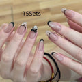 Set of medium-length coffin-shaped false nails with French manicure glitter tips and rhinestone decorations.