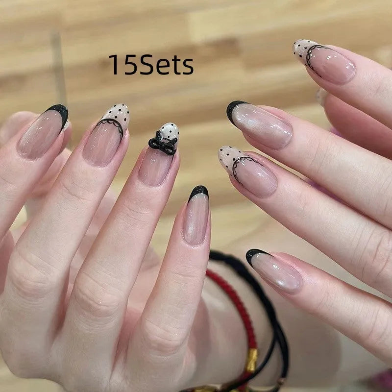 Set of medium-length coffin-shaped false nails with French manicure glitter tips and rhinestone decorations.