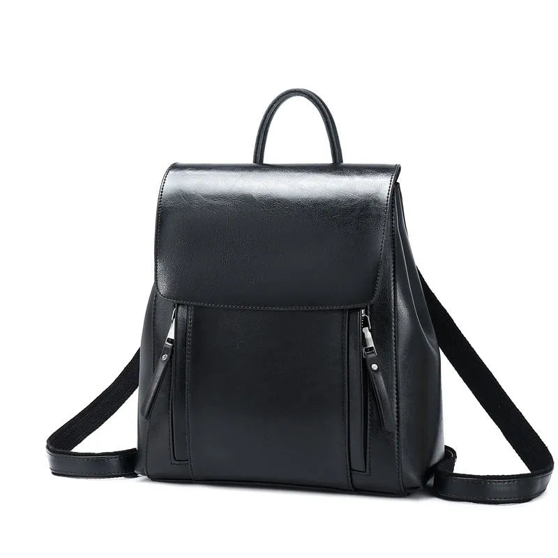 Brown oil-waxed cowhide leather women's backpack with flap closure, showing internal document pocket and stitching detail.