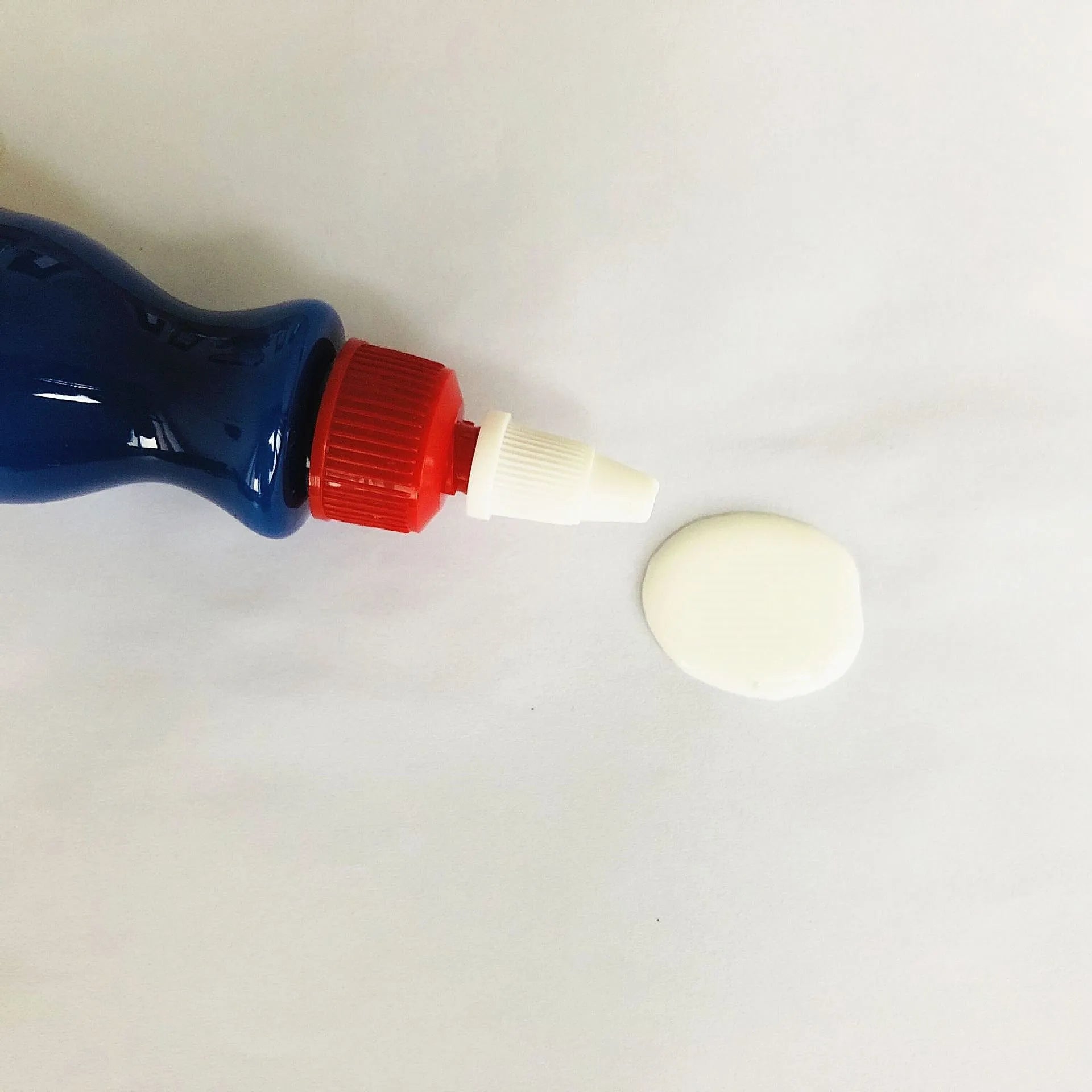 Small blue bottle of car scratch repair agent for wipe-on application to vehicle paint surfaces