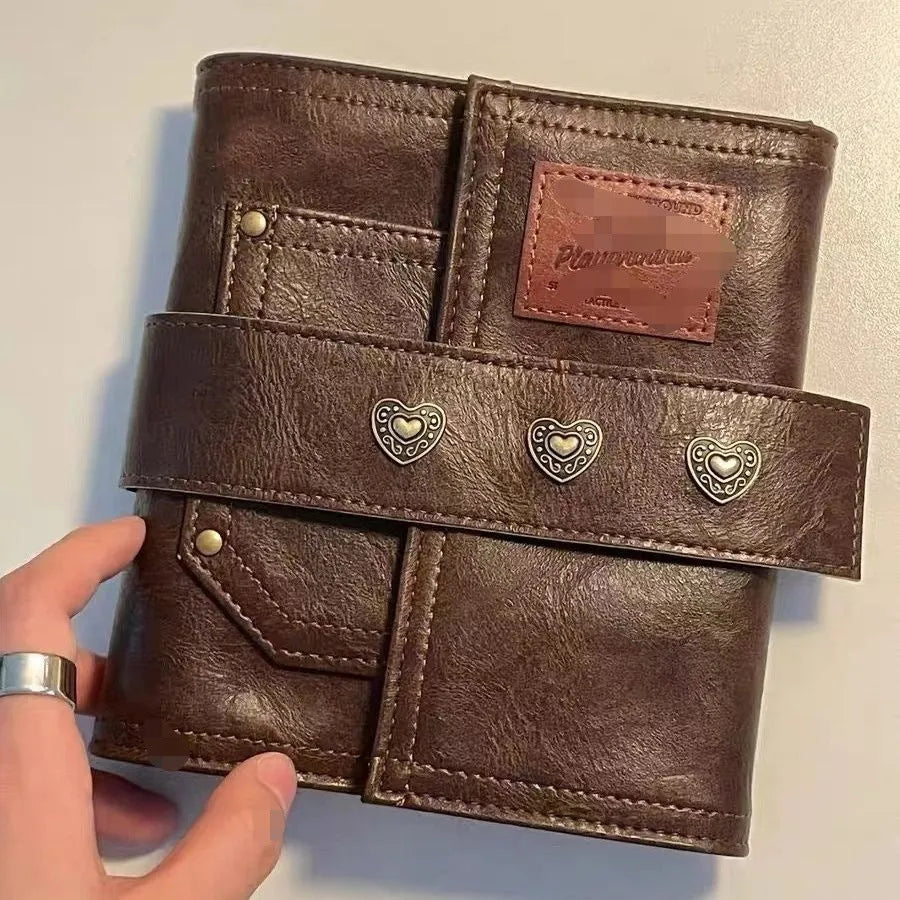 Brown retro-style A7 notebook with a PU leather-look cover and metal buckle closure, showing loose-leaf binding.