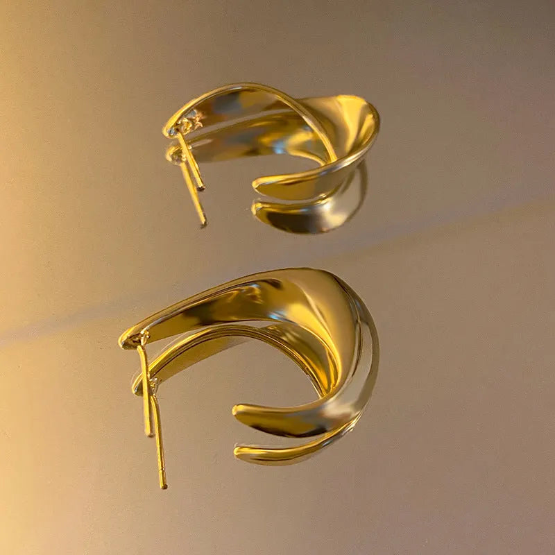 Geometric twist design metal earrings in gold or silver finish with round elements