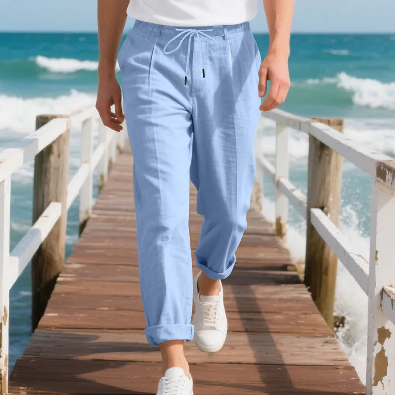Man wearing light khaki linen casual trousers with a drawstring waist and straight-leg fit.