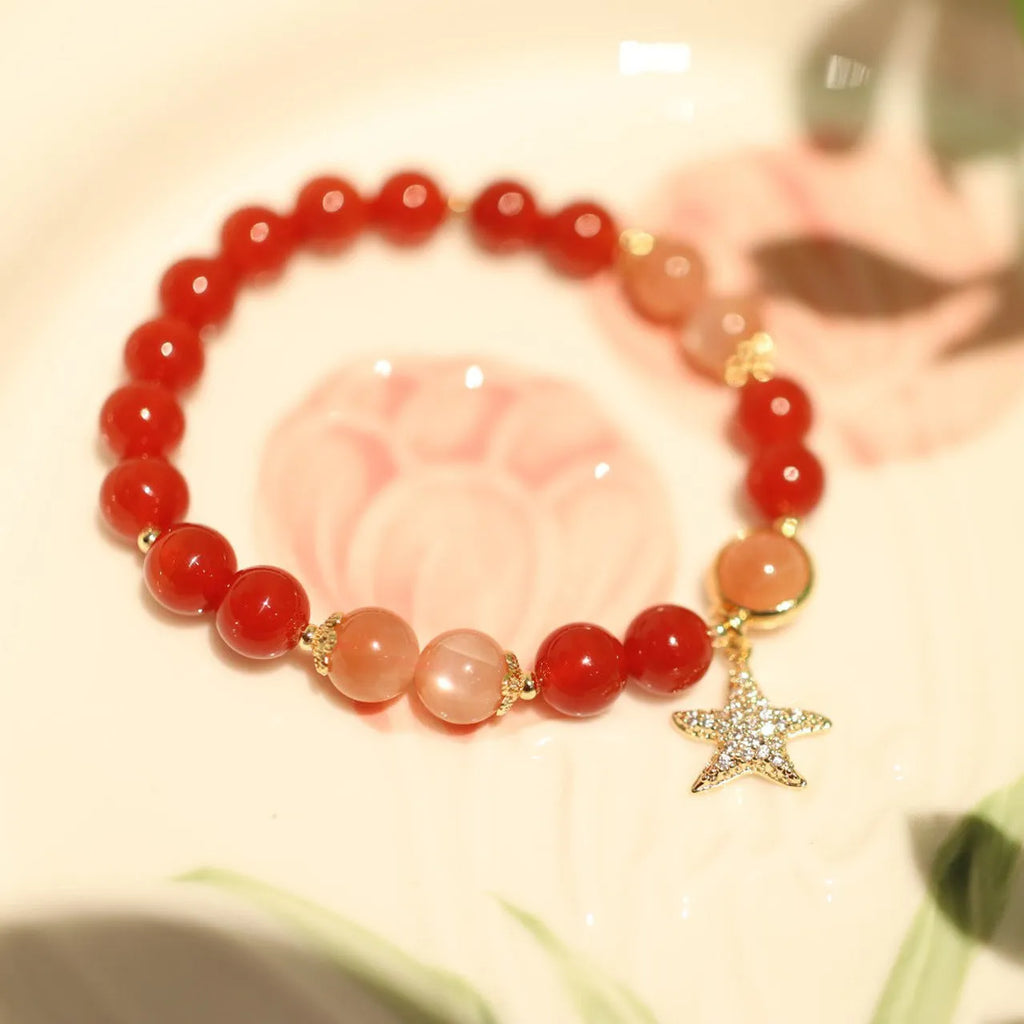 Handmade red agate and orange sunstone bracelet with star and cloud motifs