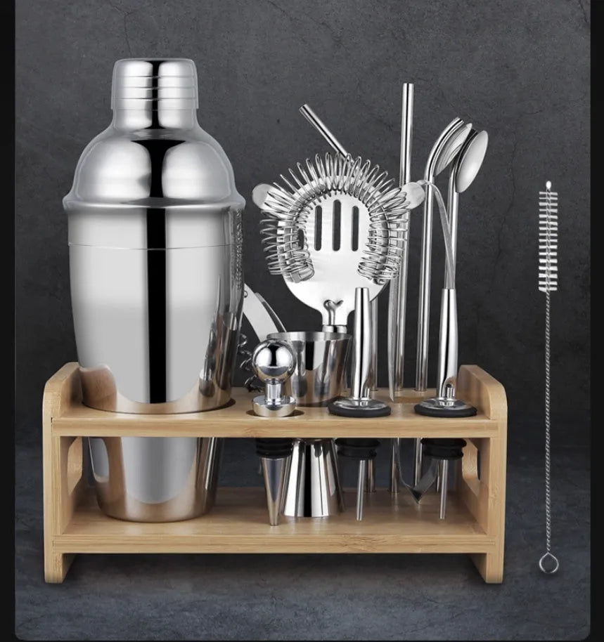 23-piece stainless steel and acrylic cocktail set with shakers, jiggers, and bar tools on a counter.