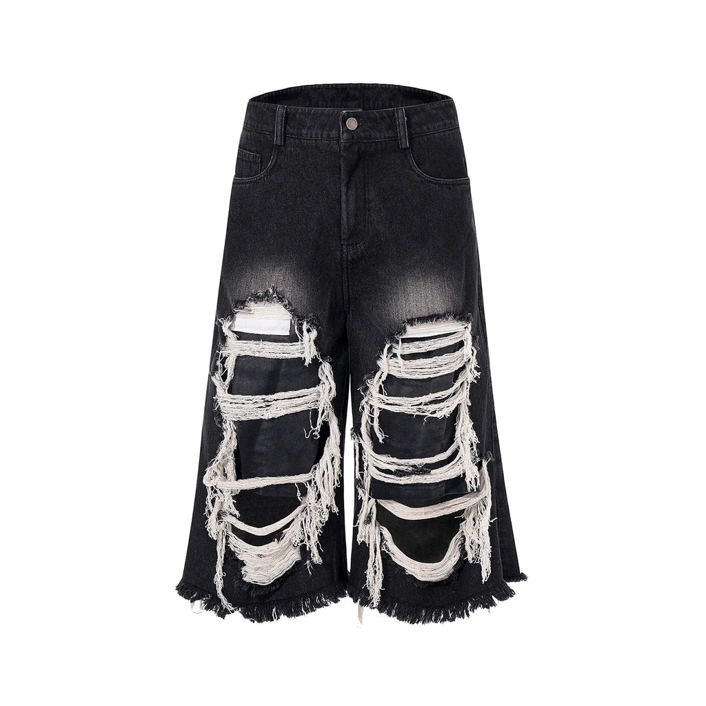 Black wide-leg cropped jeans with a ripped patch detail on the leg, shown on a model.