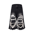Black wide-leg cropped jeans with a ripped patch detail on the leg, shown on a model.