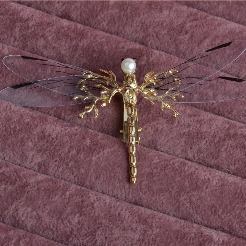 Golden dragonfly-shaped women's headdress with side clip on white background
