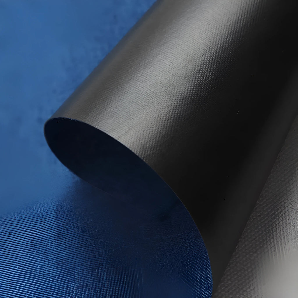 Roll of black polyester fabric with a white snowflake and dragon pattern, sold by the metre for covering projects.