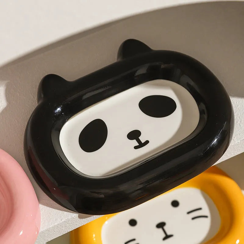 Glazed ceramic pet food bowl with animal design and non-slip rubber base ring.