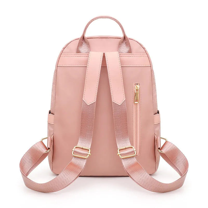 Black and pink casual nylon backpack with double straps, soft handle, and external pocket.