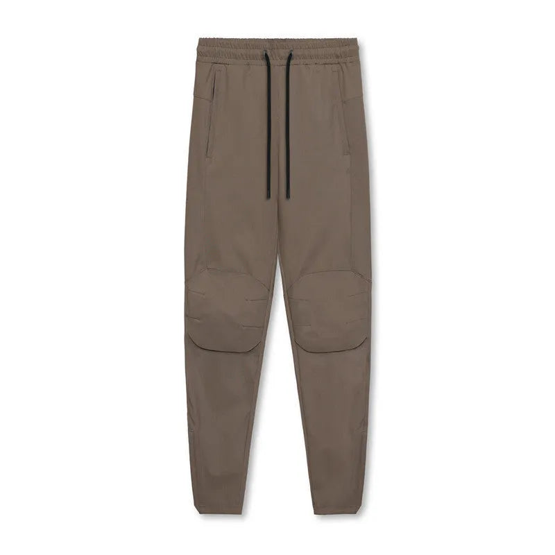 Man wearing dark grey loose-fit ankle-tied fitness trousers made from quick-drying polyester.