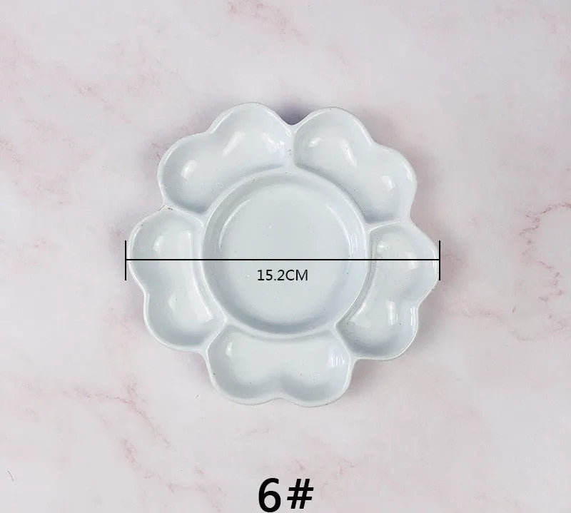 White hand-made ceramic plum blossom shaped artist palette for paint mixing.