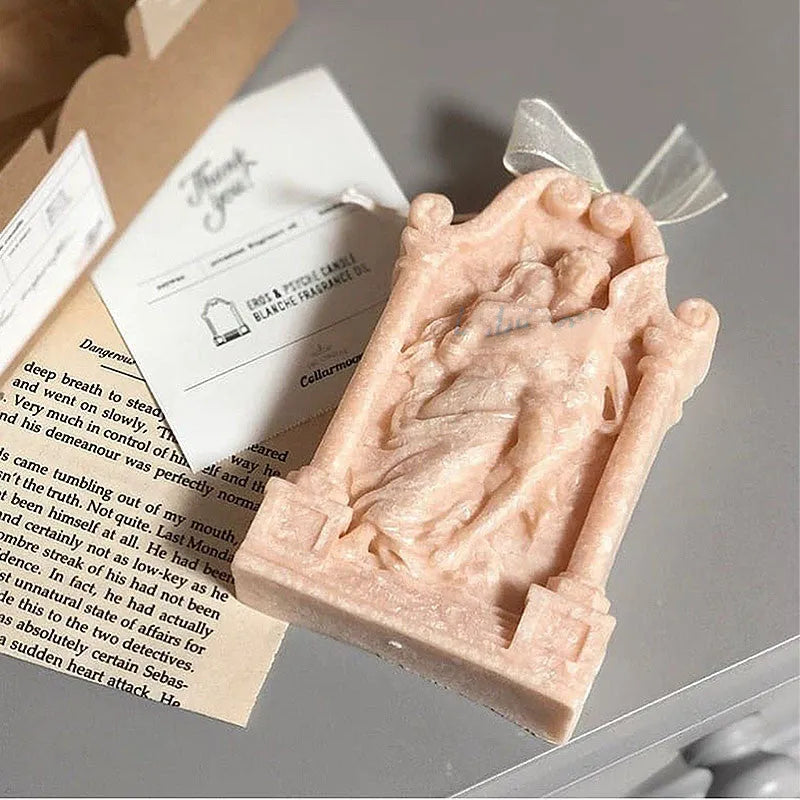Flexible food-grade silicone mold for making hug angel couple figurines from wax, chocolate, or plaster.