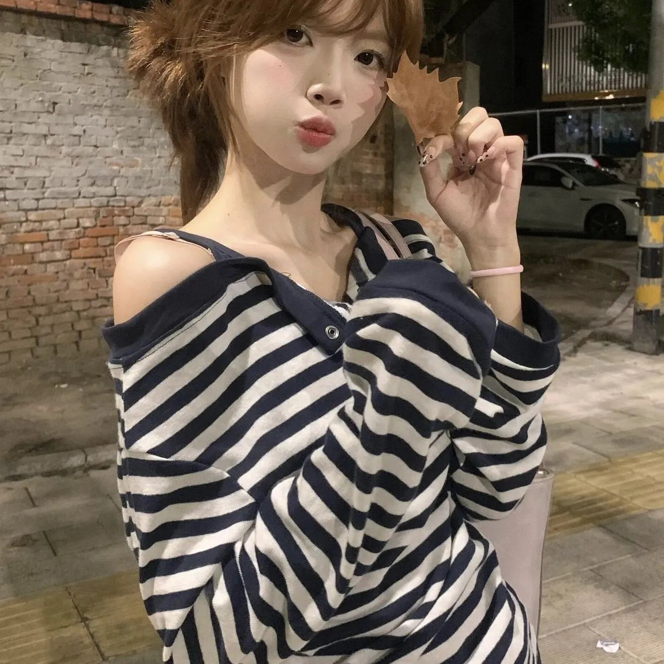 Dark blue women's oversized long-sleeve t-shirt with embroidery and stripe details on a hanger.