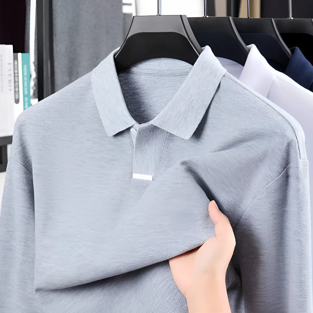 Man modelling a grey loose-fit cotton polo shirt with a lapel collar and asymmetric design.