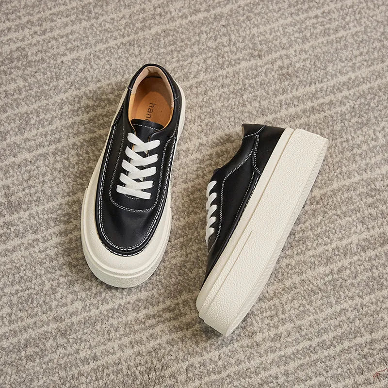 Women's black platform trainers with embossed leather upper and rubber sole