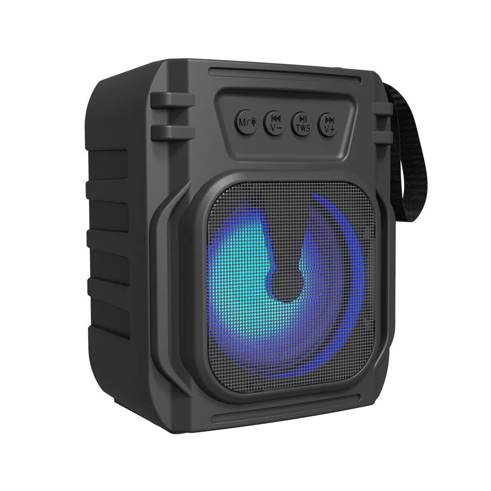 Compact rectangular portable Bluetooth speaker with USB charging cable on a desk.