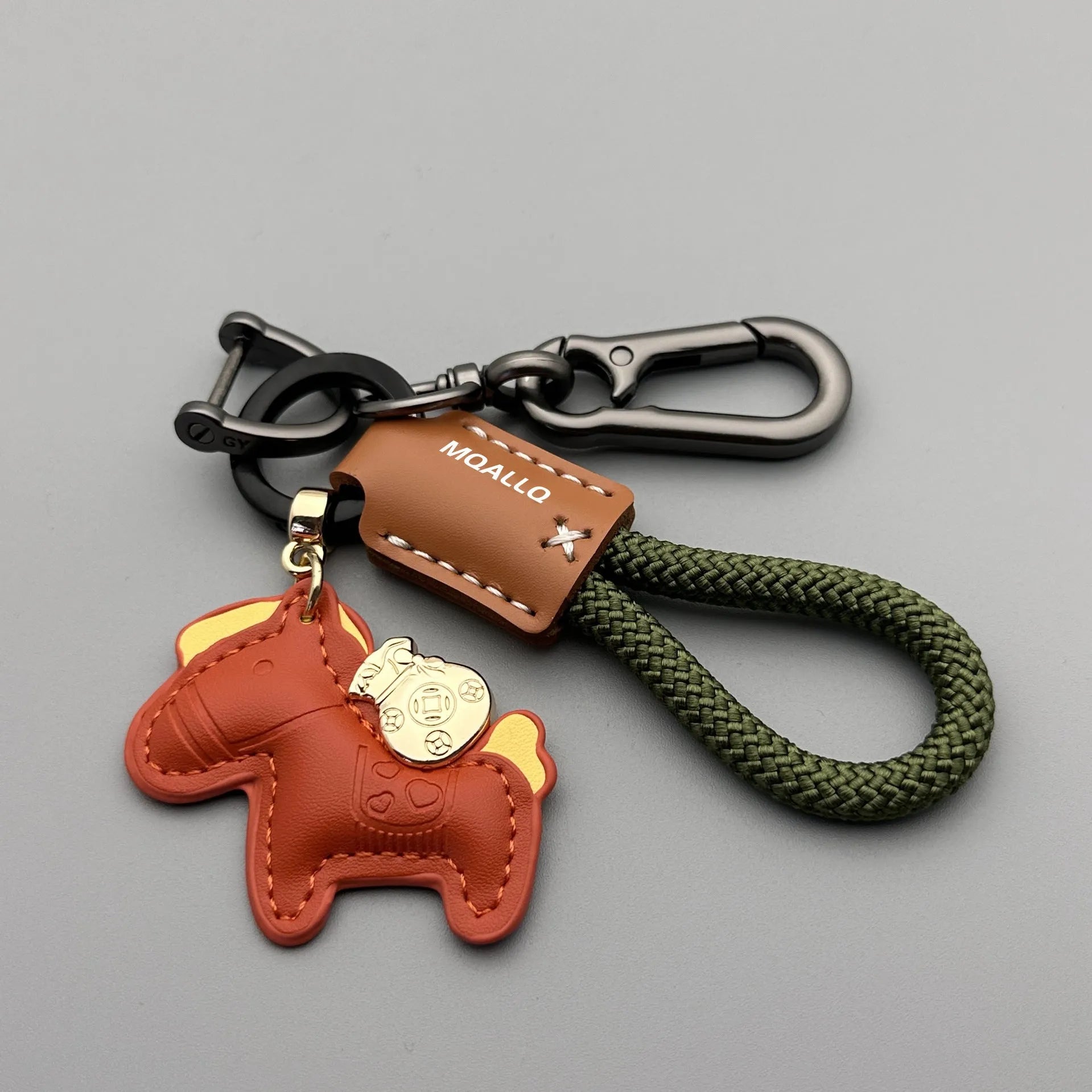 Handmade brown cowhide leather key ring with a zinc alloy pendant charm on a green flannel rope.