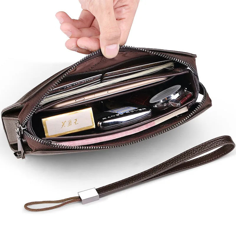 Men's black genuine leather clutch wallet open to show internal card slots, phone pocket, and zippered compartment.