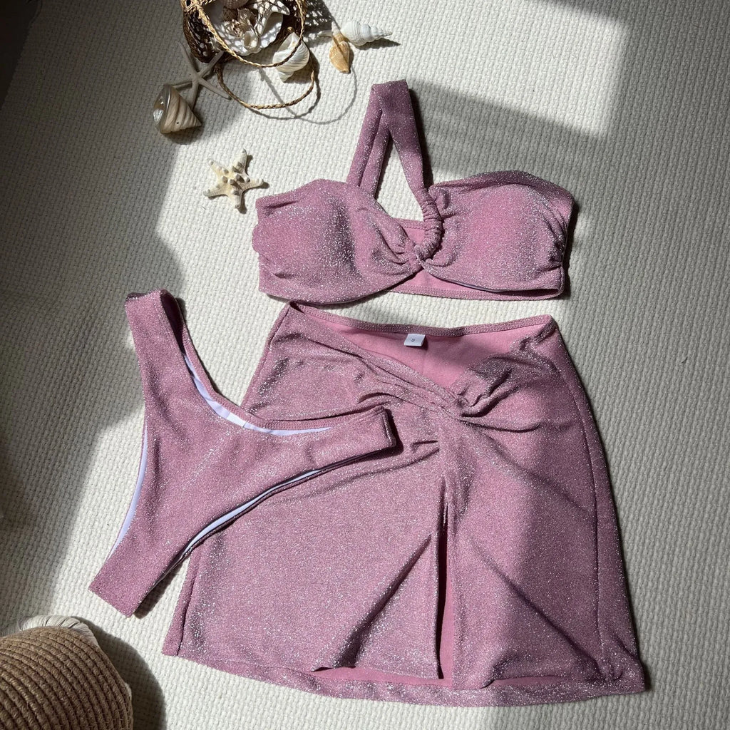 Light green one-shoulder glossy swimsuit three-piece set with matching skirt and pants.