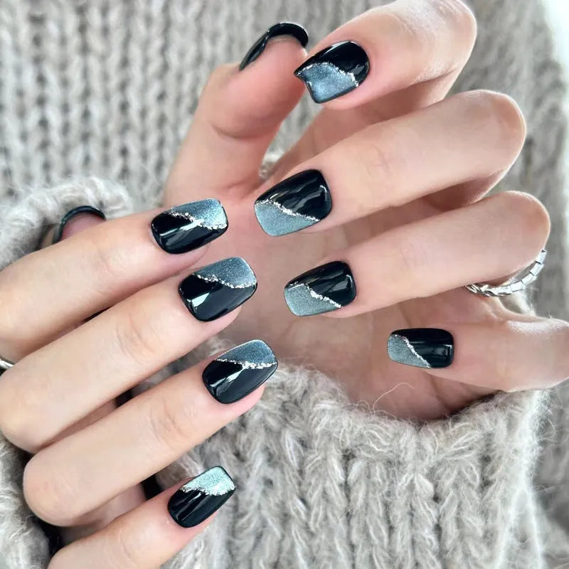 Set of medium-length coffin-shaped false nails with French manicure glitter tips and rhinestone decorations.