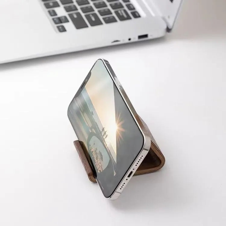 Walnut wooden mobile phone bracket on a desk, with a smartphone placed in the stand