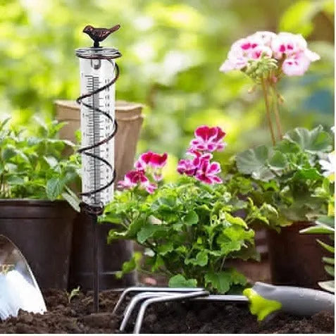Cast iron bird-shaped rain gauge with glass measurement tube showing 1-20 scale and 800ml capacity