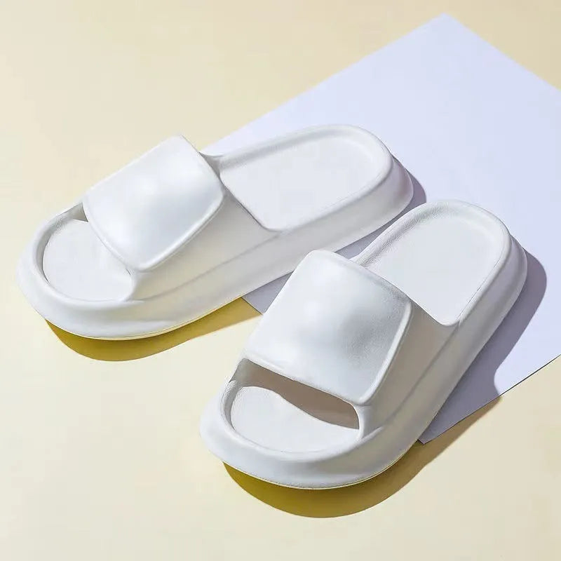 A pair of thick-soled EVA flip-flop slippers on a bathroom floor, showcasing non-slip tread and available colour options.
