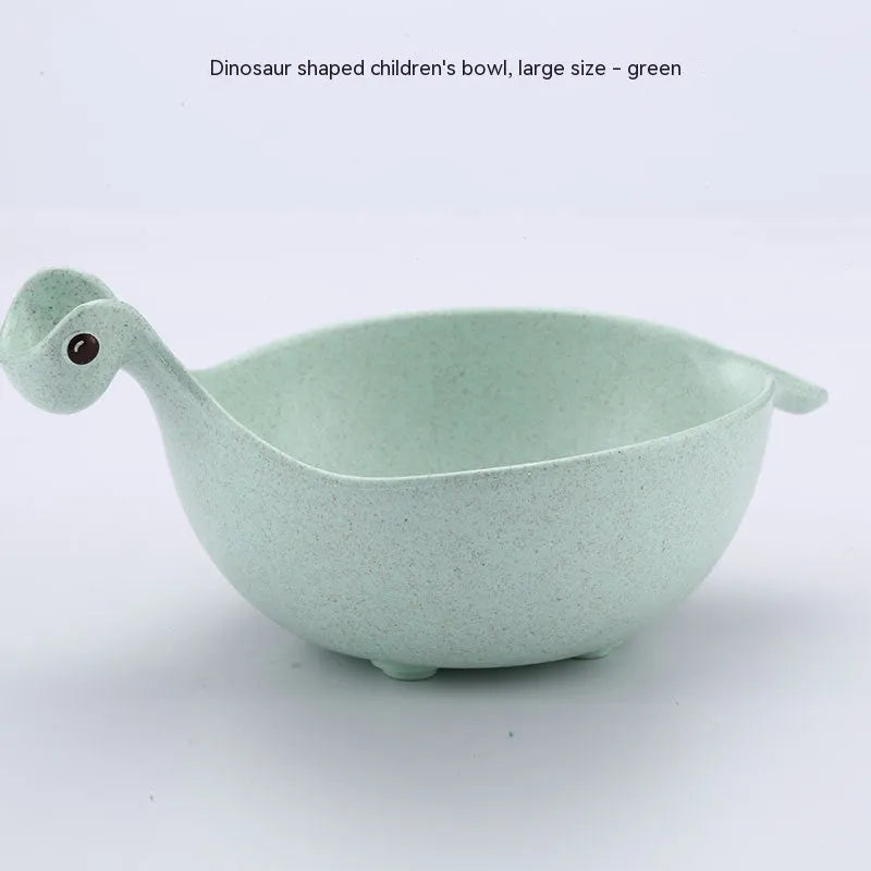 Three wheat straw dinosaur bowls in pink, green, and beige on a kitchen table