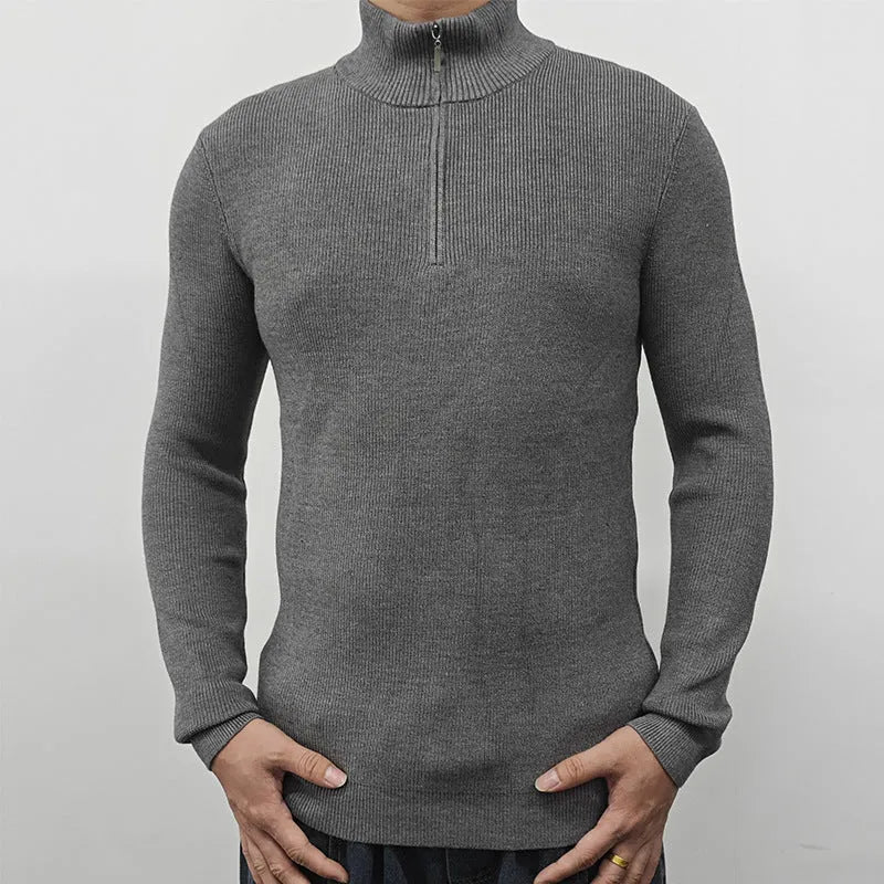 Man wearing a grey zip-front half-turtleneck sweater, a casual long-sleeve pullover.